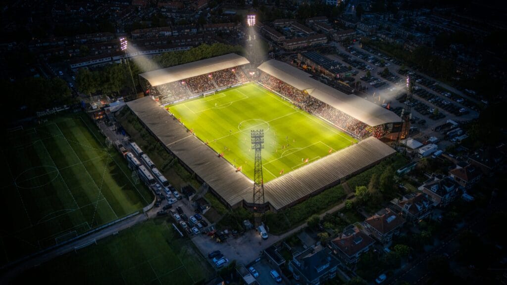 Football stadium illuminated by floodlights at night